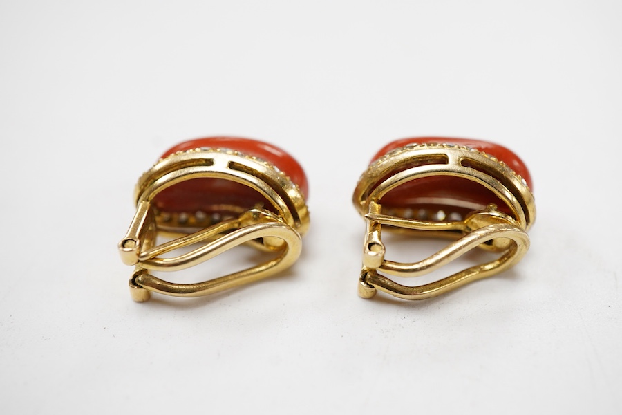 A pair of recent yellow metal, coral and diamond ear ring/clips, each oval coral bordered with diamonds, 15mm.